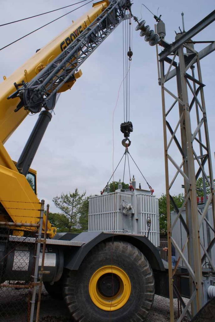 Large hoist suspending and positioning a transformer for an electrical substation